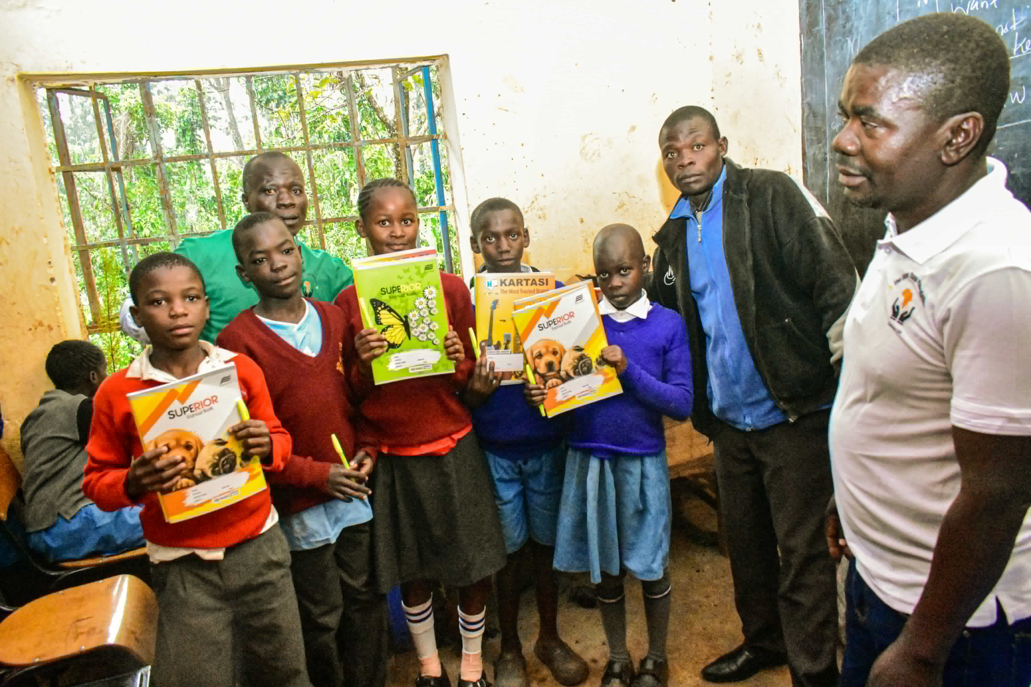 Children holding exercise books in Kenya school supported by Steve Thami Foundation