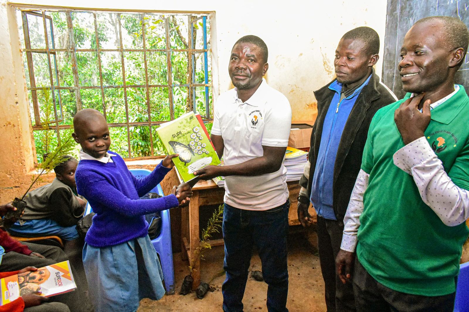 Kenyan girl receiving exercise book from Steve Thami Foundation education program